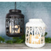 White woodland LED lantern glowing beside a black lantern on a table