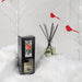 Comfort & Joy Reed Diffuser on artificial snow with cardinal bird accents